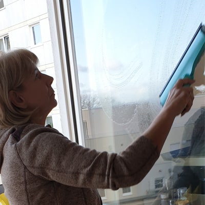Wohnungsreinigung in Steinbach, die Mitarbeiterin reinigt die Fenster